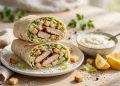 Chicken Caesar wraps cut in half showing grilled chicken, romaine lettuce and creamy Caesar dressing inside soft tortillas