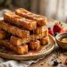 Golden cinnamon French toast sticks stacked on a plate, dusted with cinnamon sugar, maple syrup dripping