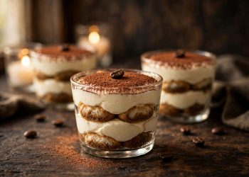 Elegant no-bake tiramisu served in glass dessert cups, dusted with cocoa powder