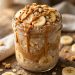 Mason jar of peanut butter banana overnight oats topped with banana slices, peanut butter drizzle and granola