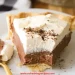 A slice of Chocolate Cream Pie with a flaky crust, creamy chocolate filling, and a thick layer of whipped cream sits on a white plate, a forkful already enjoyed.