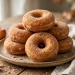 Cinnamon sugar coated baked apple cider donuts stacked on a rustic plate
