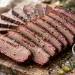 Sliced BBQ beef brisket on a cutting board with barbecue sauce