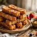 Golden cinnamon French toast sticks stacked on a plate, dusted with cinnamon sugar, maple syrup dripping