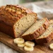 Golden-brown banana bread loaf with crackled top, sliced to show a moist tender crumb
