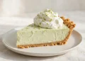 Slice of key lime pie with whipped cream and lime zest