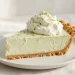 Slice of key lime pie with whipped cream and lime zest