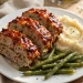Sliced turkey meatloaf with caramelized ketchup glaze on a serving plate