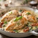 Creamy garlic Tuscan chicken with sun-dried tomatoes and spinach in a cast-iron skillet