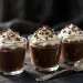 Dark chocolate mousse in glasses topped with whipped cream and shavings