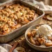 Homemade apple crisp with vanilla ice cream in a rustic baking dish