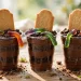Halloween graveyard dirt cups with cookie tombstones and gummy worms in clear cups