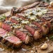 Grilled ribeye steak sliced on a board with melted garlic herb butter