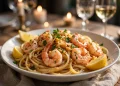 Honey garlic butter shrimp pasta twirled in a bowl with plump shrimp, parsley, and lemon
