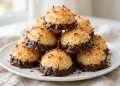 Chocolate-dipped coconut macaroons piled on a plate