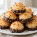 Chocolate-dipped coconut macaroons piled on a plate