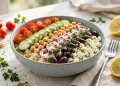 Mediterranean quinoa power bowl with chickpeas, feta, tomatoes, cucumber, olives and tahini dressing