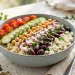 Mediterranean quinoa power bowl with chickpeas, feta, tomatoes, cucumber, olives and tahini dressing