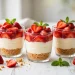No-bake strawberry cheesecake cups layered with graham crust, creamy filling, and fresh strawberries