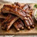 Oven-baked BBQ pork ribs with glossy caramelized sauce on a wooden board