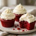 Red velvet cupcakes topped with swirled cream cheese frosting