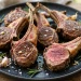 Rosemary garlic lamb chops seared golden brown on a dark platter