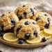 Golden blueberry lemon scones with a lemon glaze drizzle, studded with juicy blueberries, on a rustic plate with lemon slices