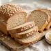 Golden whole wheat sandwich bread loaf, sliced, showing soft crumb on a wooden board
